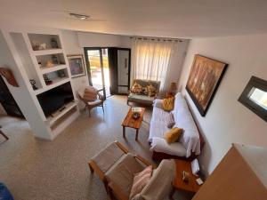een woonkamer met een bank en een tv bij Alquilaencanarias Duplex Playa del Médano in El Médano