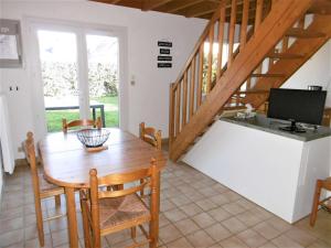 a kitchen and dining room with a table and a television at Maisonnette 5 pièces 6 personnes avec WIFI - JUNA in Sarzeau