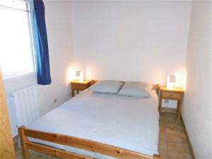 a bedroom with a bed with two lamps on two tables at Maisonnette 5 pièces 6 personnes avec WIFI - JUNA in Sarzeau