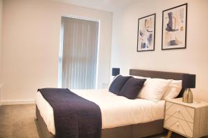 a bedroom with a large bed and a window at AP- Luxury Apt nxt to o2 Academy in Birmingham
