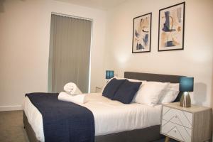 a bedroom with a large white bed with blue pillows at AP- Luxury Apt nxt to o2 Academy in Birmingham