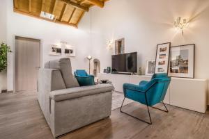 un soggiorno con divano e 2 sedie di Veronetta Stunning Rooftop with Lift a Verona