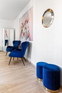 a room with blue chairs and a mirror at La vie est belle in Bucharest