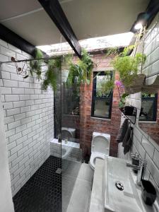a bathroom with a shower and a toilet and a sink at The Secret Garden Hideaway in Mossel Bay