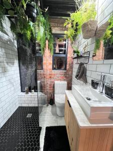 a bathroom with a toilet and a sink with plants at The Secret Garden Hideaway in Mossel Bay