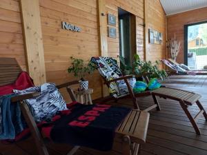 贝尔凯尔Les Chalets du Lac Belcaire的小屋的门廊上有两把椅子和一张桌子 更多37张照片