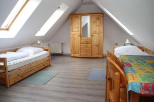 a attic bedroom with two beds and a door at Fewo Peeneblick 5_LIND in Ostseebad Karlshagen