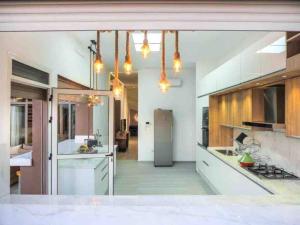 a large kitchen with white cabinets and a refrigerator at Eden Villa in Marrakech