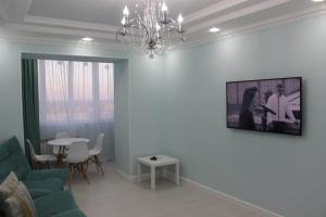 - un salon avec un canapé et un lustre dans l'établissement Двухкомнатная квартира в центре города, à Uralsk