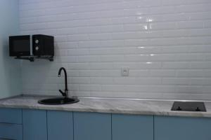 - un comptoir de cuisine avec évier et une télévision dans l'établissement Двухкомнатная квартира в центре города, à Uralsk