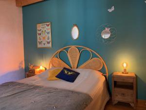 een slaapkamer met een bed met een blauwe muur bij La Magnanerie de Dions in Dions