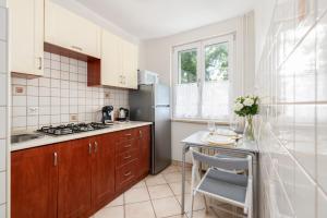 a kitchen with a counter and a sink and a refrigerator at Apartment Floriana Stablewskiego Poznań by Renters in Poznań