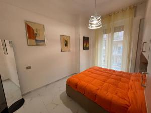 a bedroom with an orange bed and a window at Dolce Vita A 5 Minuti Dal Centro Con Parcheggio Privato in Sanremo