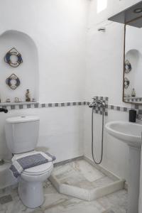 a white bathroom with a toilet and a sink at Elysium Paros Houses in Chrissi Akti