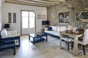 a living room with a couch and a table at Elysium Paros Houses in Chrissi Akti