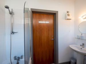 baño con puerta de madera y lavamanos en Pass the Keys Modern flat a short walk from Shrewsbury centre, en Shrewsbury