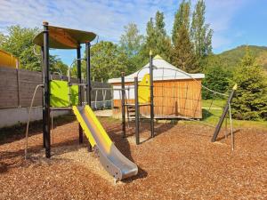 a playground with a slide and a play structure at Les Chalets du Lac Belcaire in Belcaire