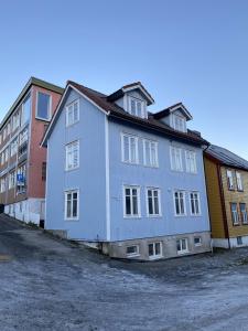 un bâtiment bleu et blanc à côté de certains bâtiments dans l'établissement Enter Tromsø - Luxury 4 Bedroom Apartment, à Tromsø