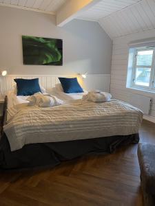 a bedroom with a large bed with blue pillows at Enter Tromsø - Luxury 4 Bedroom Apartment in Tromsø