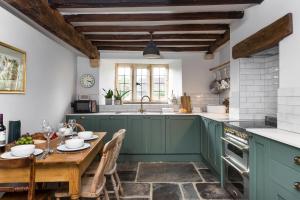 a kitchen with green cabinets and a wooden table at 1 Chestnut Corner in Stanton
