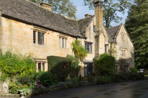 an old stone house with flowers in front of it at 1 Chestnut Corner in Stanton