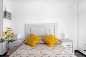 um quarto com uma cama com duas almofadas amarelas em Bulto Carihuela B em Torremolinos