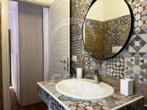 a bathroom with a sink and a mirror at CASA ROSSELLA in Torre Lapillo +18 photos