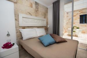 a bedroom with a bed with a brick wall at Calaporto-Holiday Home & Relax in Polignano a Mare