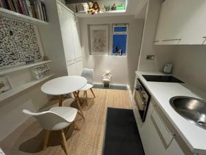 a small kitchen with a table and a sink at Modern self-contained Ground and Basement studios in London