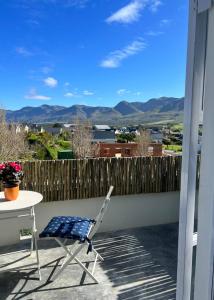 a chair and a table on a balcony with mountains at A Mountain & Country Haven in Stanford