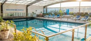 a swimming pool with blue chairs in a building at HOTEL dGATES in Lahore
