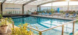 拉合爾的住宿－HOTEL dGATES，大楼内带蓝色椅子的游泳池