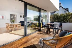 a living room with sliding glass doors and a table and chairs at 7 The Bay in Coldingham