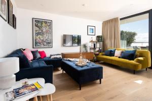 a living room with two blue couches and a yellow couch at 7 The Bay in Coldingham