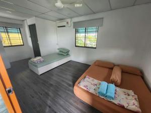 Simpang EmpatにあるHomestay Denai Harummanis S4のベッド1台とソファが備わる小さな客室です。