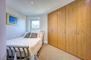 - une chambre avec un lit et des placards en bois dans l'établissement Atico, à Newcastle upon Tyne