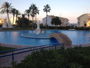 eine Statue eines Schwans in der Mitte eines Schwimmbeckens in der Unterkunft Modern Penthouse-duplex Facing The Sea in La Torre