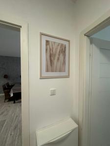 zdjęcie na ścianie nad toaletą w łazience w obiekcie Airport Apartment Regata Kiekrz lotnisko w mieście Baranowo +28 zdjęć