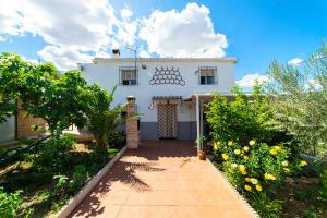 a white house with a pathway in front of it at Casa Carmen, Montefrio in Montefrío