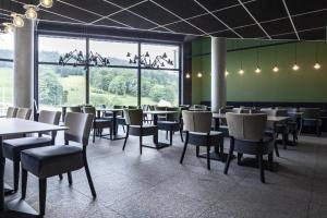 a restaurant with tables and chairs and a large window at Apartament Bellavue w Czarnej Perle in Stronie Śląskie