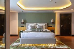 a bedroom with a large white bed with a rug at Best Hotel in Lagos - The Delborough in Lagos