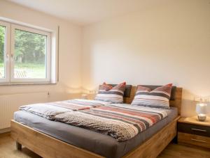 Schlafzimmer mit einem großen Bett und einem Fenster in der Unterkunft Hof am Horn - Fewos in der Natur in Laichingen