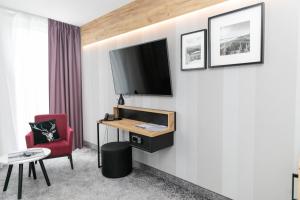 a hotel room with a tv and a red chair at Apartament Bellavue w Czarnej Perle in Stronie Śląskie