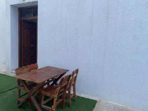 een houten tafel en twee stoelen naast een muur bij S+2 Corniche Nord in Bizerte
