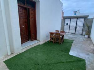 une petite terrasse avec une table et des chaises sur la pelouse dans l'établissement S+2 Corniche Nord, à Bizerte