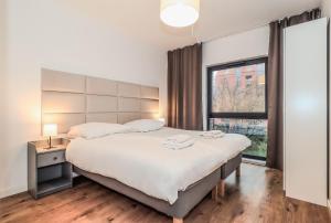 een slaapkamer met een groot bed en een raam bij Platinium Dwie Motławy River View in Gdańsk