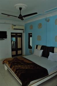 a large bed in a bedroom with blue walls at Hotel Pratap Palace in Bharatpur