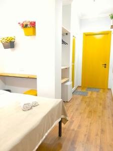 um quarto com uma cama e uma porta amarela em Hotel NBL Color in em Tbilisi