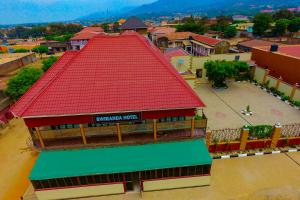 a building with a red roof in a town at Bwiranda Hotel in Kasese