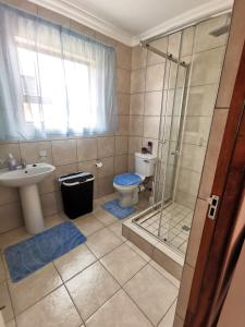 a bathroom with a shower and a toilet and a sink at MV self-catering - Units in Bloemfontein